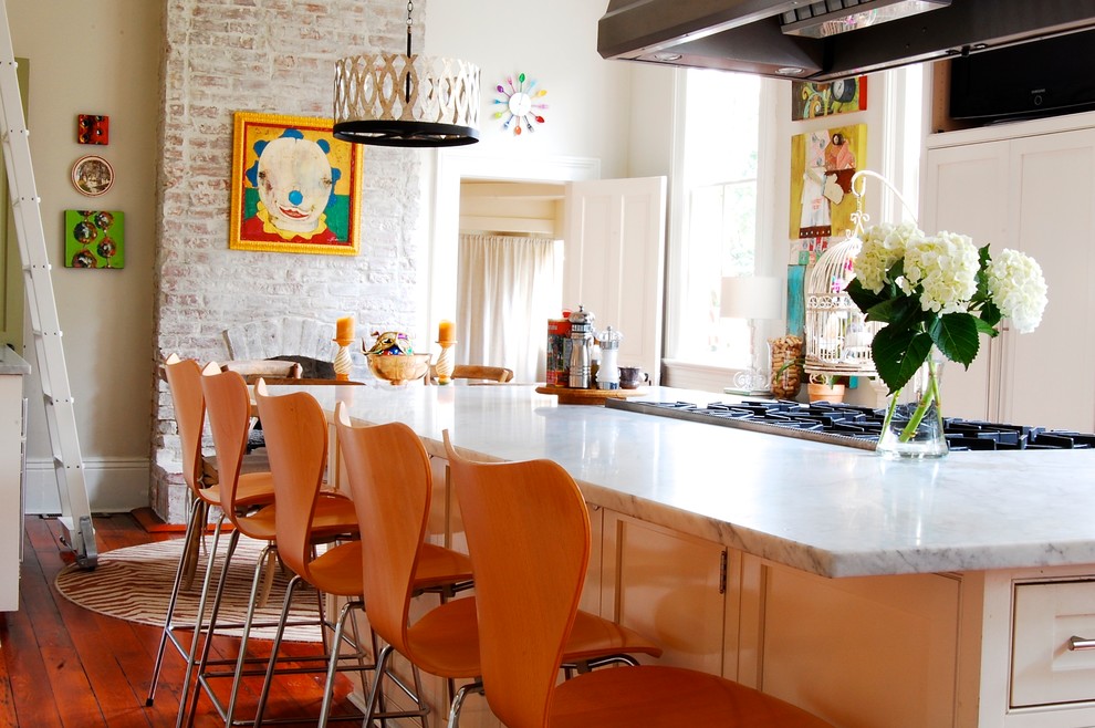 Eclectic eat-in kitchen in New York with white cabinets.