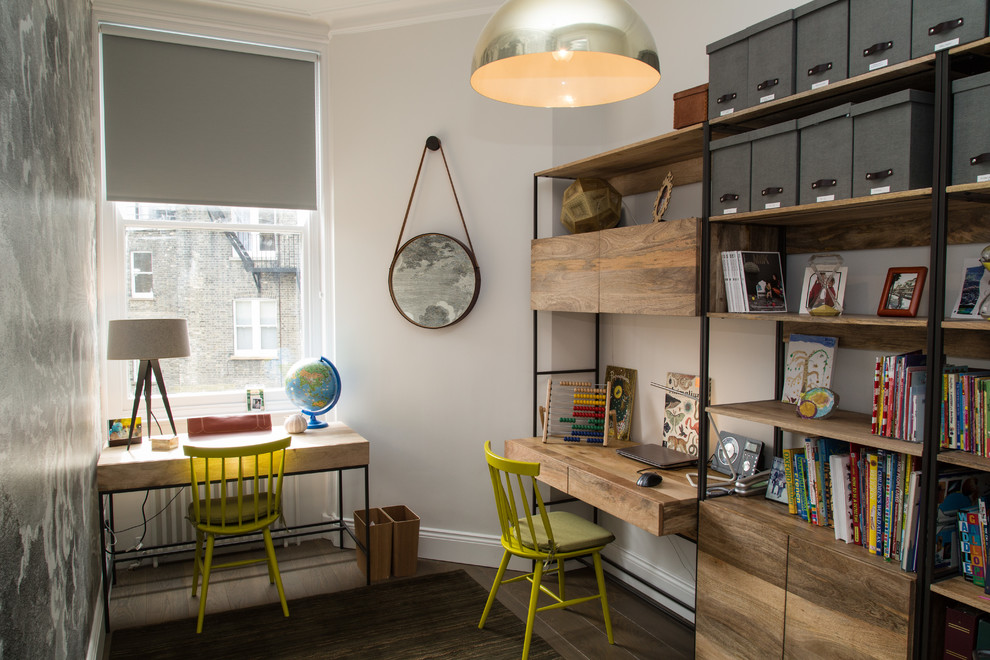 This is an example of a mid-sized contemporary gender-neutral kids' study room in London with beige walls, medium hardwood floors and brown floor.