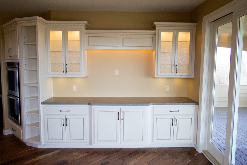 Open concept kitchen - huge open concept kitchen idea with a drop-in sink, raised-panel cabinets, white cabinets, multicolored backsplash, stone tile backsplash, stainless steel appliances and an island