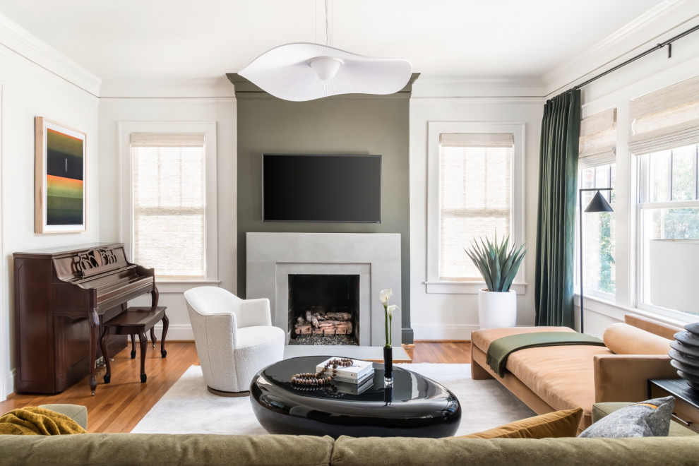 Cette photo montre une salle de séjour tendance de taille moyenne et ouverte avec un sol en bois brun, une cheminée standard, un manteau de cheminée en carrelage, un téléviseur fixé au mur et un mur vert.