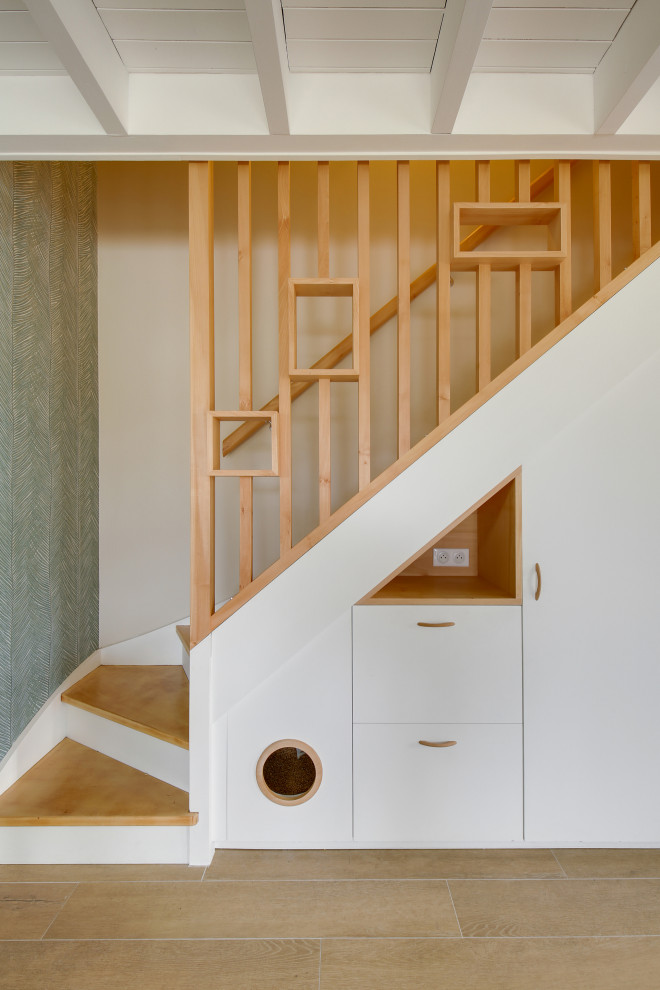 Ejemplo de escalera en L escandinava de tamaño medio con escalones de madera, contrahuellas de madera pintada, barandilla de madera y papel pintado