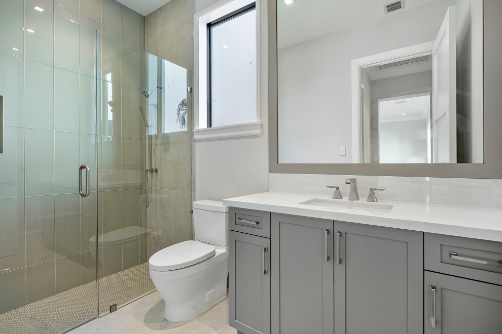 Design ideas for a mid-sized transitional 3/4 bathroom in Miami with beaded inset cabinets, grey cabinets, an alcove shower, a one-piece toilet, beige tile, glass tile, grey walls, dark hardwood floors, a vessel sink, quartzite benchtops, brown floor, a hinged shower door, white benchtops, a single vanity, a floating vanity and wallpaper.