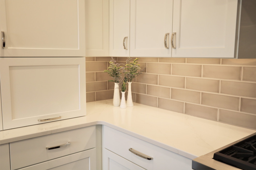 Huge transitional u-shaped dark wood floor and brown floor eat-in kitchen photo in Cincinnati with an undermount sink, recessed-panel cabinets, white cabinets, quartz countertops, beige backsplash, subway tile backsplash, stainless steel appliances, an island and white countertops