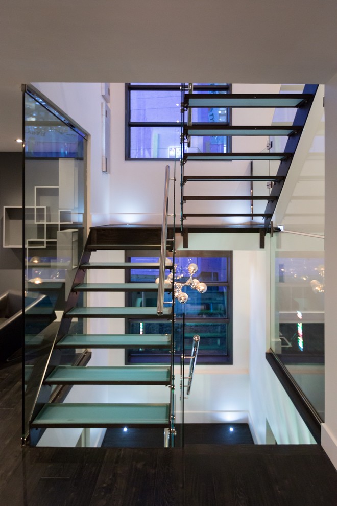 Photo of a large modern glass u-shaped staircase in Edmonton with open risers.