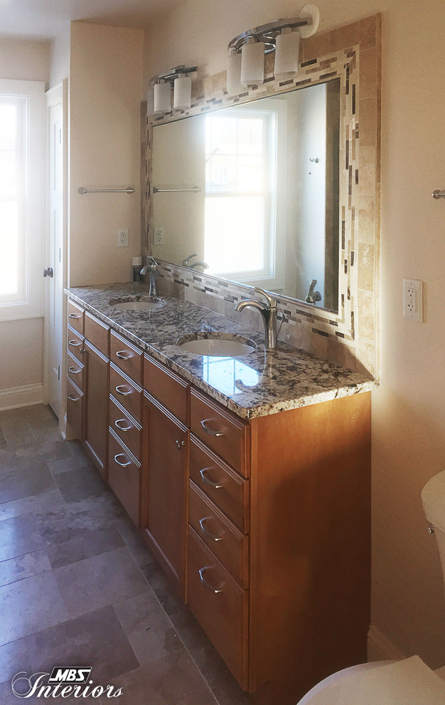 Bathroom - large transitional medium tone wood floor bathroom idea in Cincinnati with an undermount sink, recessed-panel cabinets, dark wood cabinets, quartz countertops, beige backsplash, stone tile backsplash, stainless steel appliances and an island