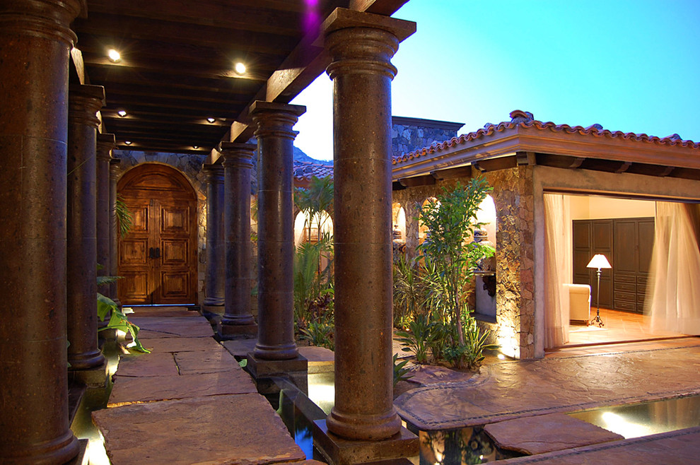 Mediterranean entryway in Mexico City with a double front door and a dark wood front door.