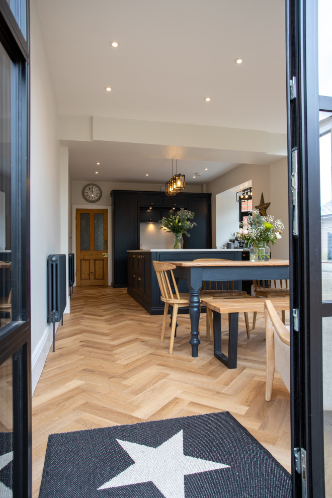 Aménagement d'une salle à manger ouverte sur le salon classique de taille moyenne avec un sol en bois brun, un sol marron, un mur blanc et éclairage.