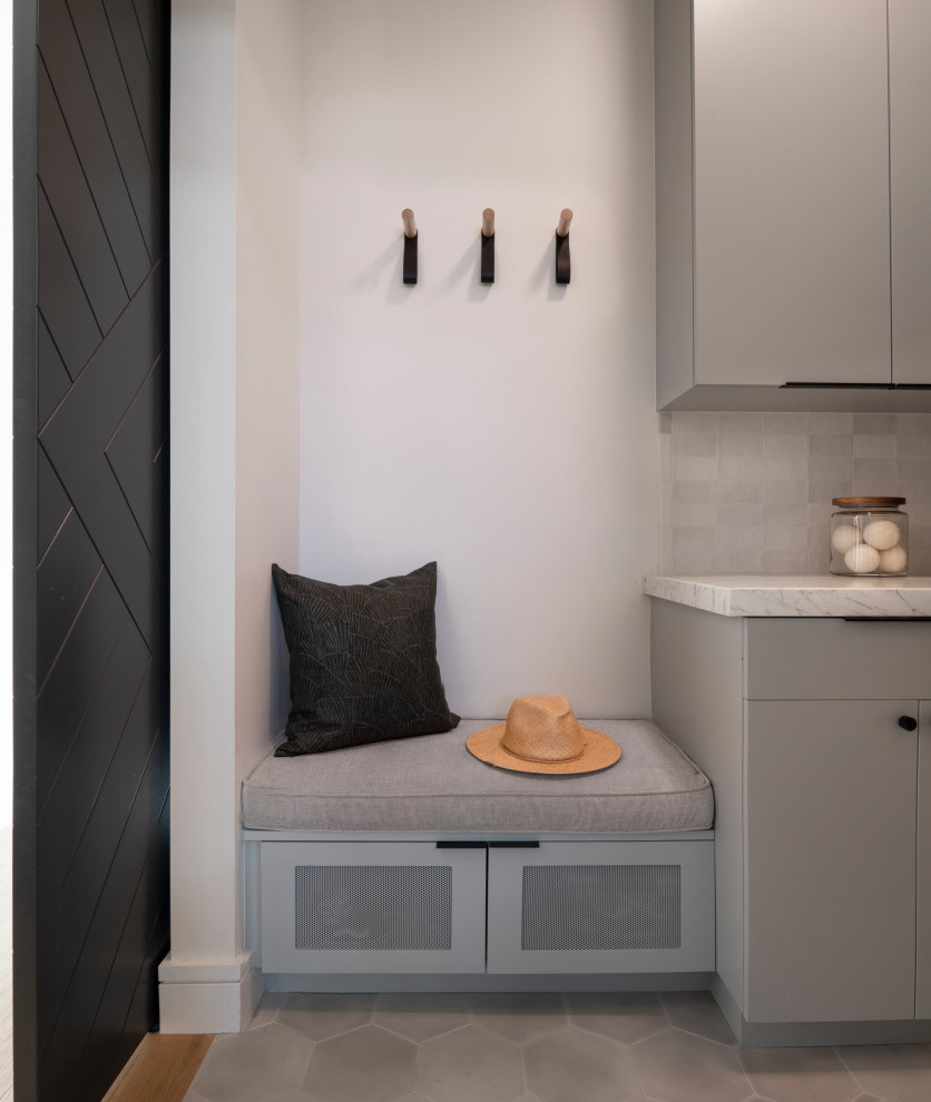 Photo of a small contemporary l-shaped dedicated laundry room in San Francisco with flat-panel cabinets, grey cabinets, marble benchtops, white splashback, ceramic splashback, white walls, grey floor and white benchtop.