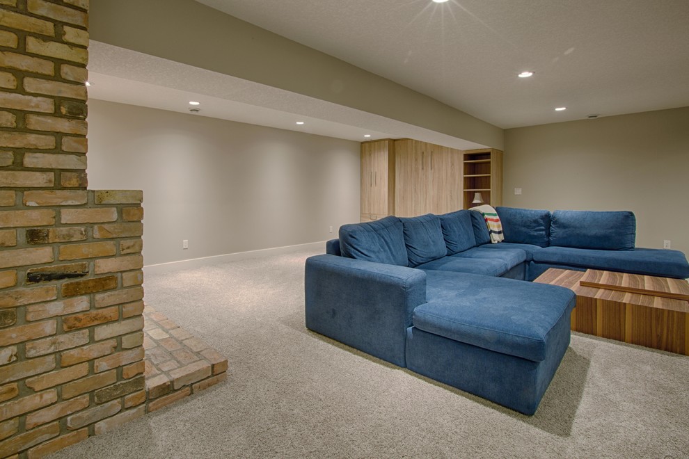 Large transitional look-out carpeted and gray floor basement photo in Calgary with beige walls, a standard fireplace and a brick fireplace
