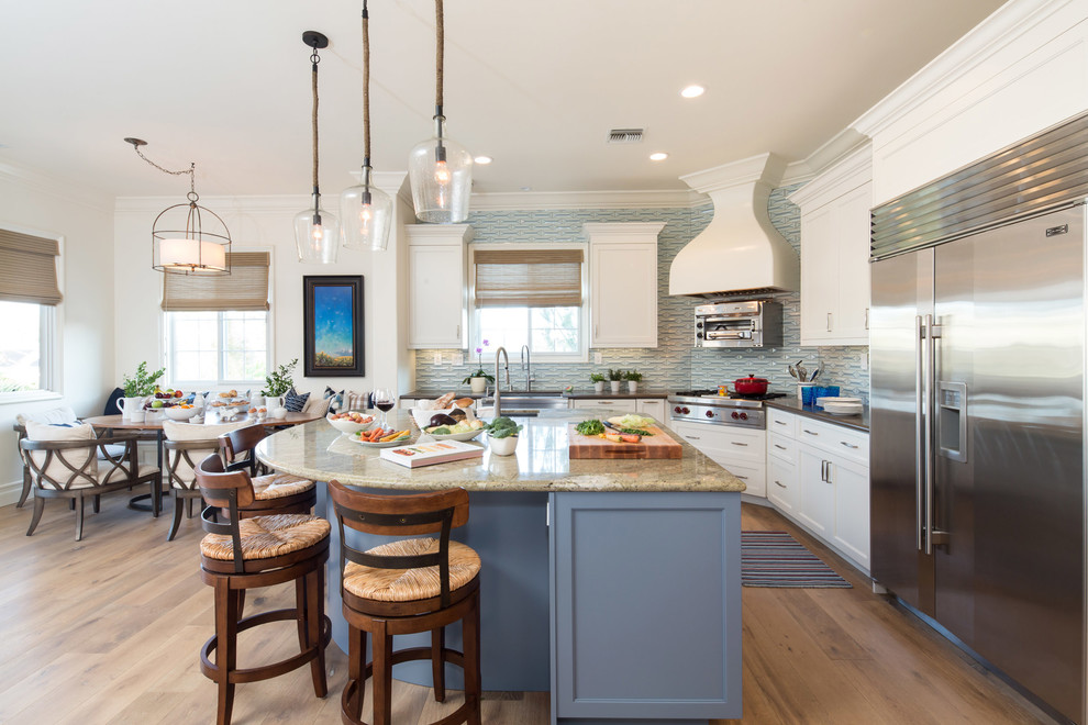 Photo of a large traditional u-shaped eat-in kitchen in Los Angeles with an undermount sink, shaker cabinets, white cabinets, granite benchtops, blue splashback, ceramic splashback, stainless steel appliances, with island and medium hardwood floors.