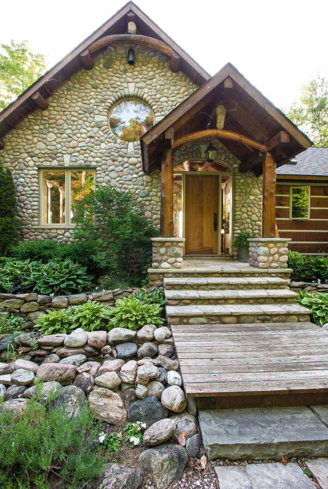 Inspiration for a rustic one-story stone front door remodel in Toronto with a medium wood front door