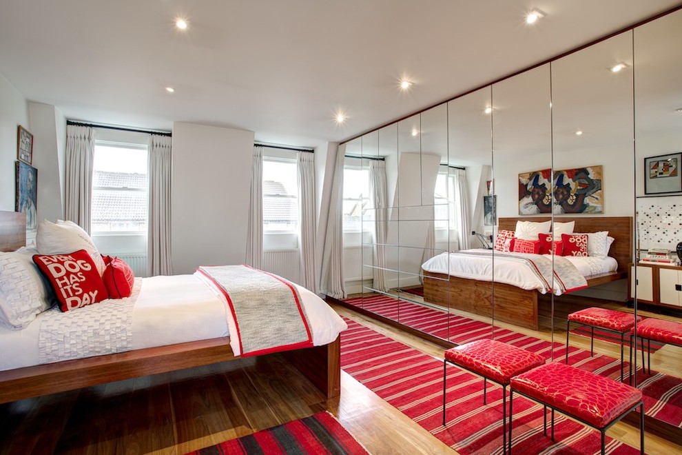 Design ideas for a contemporary bedroom in London with white walls and light hardwood floors.