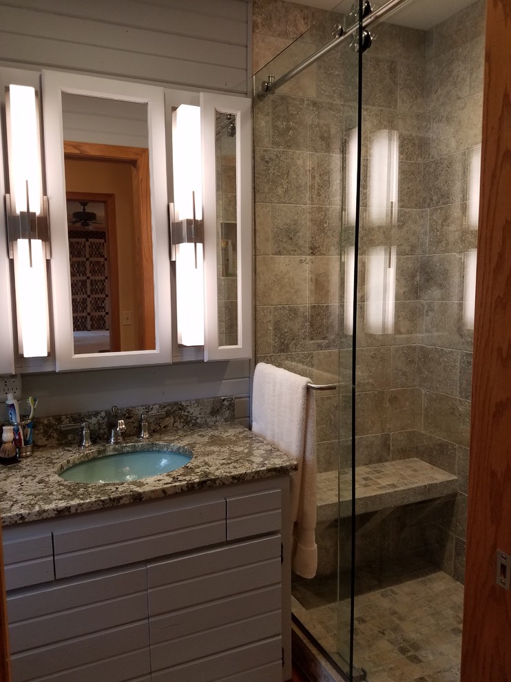 Example of a mid-sized mountain style master gray tile and travertine tile medium tone wood floor and brown floor alcove shower design with flat-panel cabinets, gray cabinets, a two-piece toilet, gray walls, an undermount sink and granite countertops