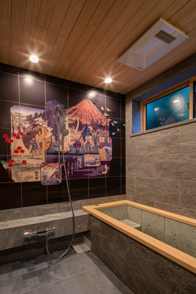 На фото: ванная комната с японской ванной, серыми стенами, полом из керамической плитки, серым полом, деревянным потолком и панелями на части стены с