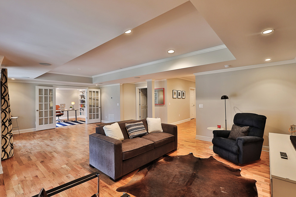 This is an example of a mid-sized transitional walk-out basement in Atlanta with grey walls, light hardwood floors and no fireplace.