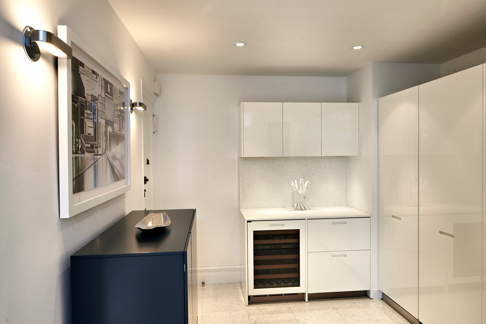 Photo of a contemporary kitchen in New York with flat-panel cabinets and white cabinets.