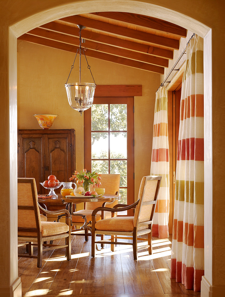 Inspiration for a mediterranean dining room in San Francisco with beige walls and dark hardwood floors.
