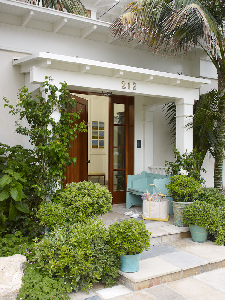 Design ideas for a tropical front yard verandah in Los Angeles.