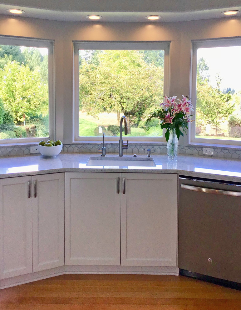 This is an example of a large arts and crafts u-shaped eat-in kitchen in Portland with an undermount sink, shaker cabinets, grey cabinets, granite benchtops, white splashback, marble splashback, coloured appliances, light hardwood floors, a peninsula, brown floor and white benchtop.