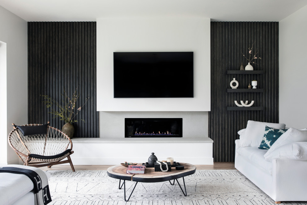 Стильный дизайн: гостиная комната в современном стиле с белыми стенами и телевизором на стене - последний тренд