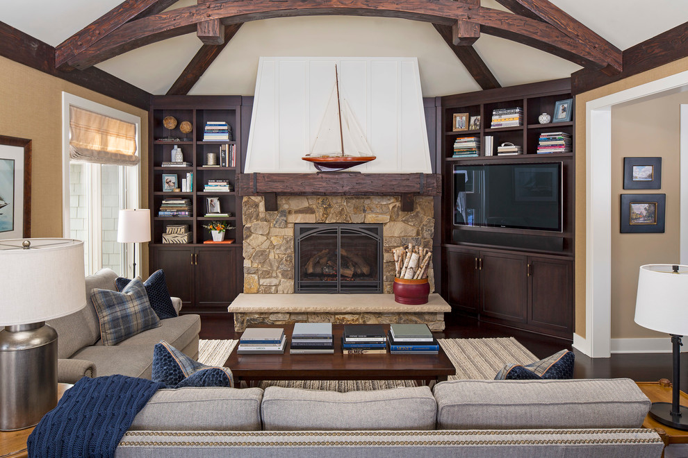 This is an example of a traditional enclosed living room in Minneapolis with a library, beige walls, a standard fireplace, a built-in media wall, dark hardwood floors and a stone fireplace surround.