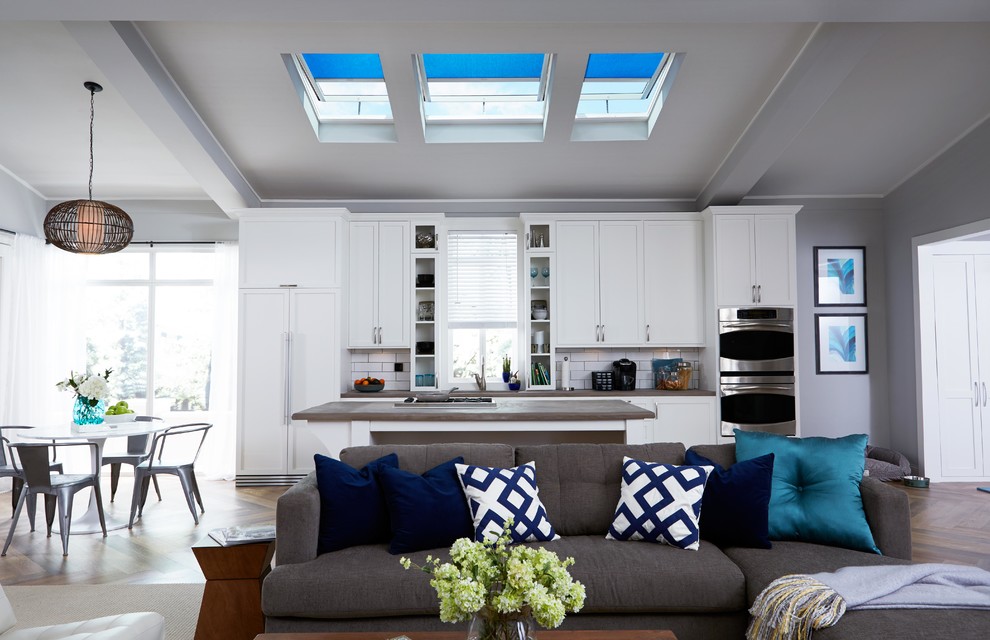 Example of a mid-sized transitional galley dark wood floor open concept kitchen design in Denver with an undermount sink, shaker cabinets, white cabinets, wood countertops, white backsplash, subway tile backsplash, stainless steel appliances and an island