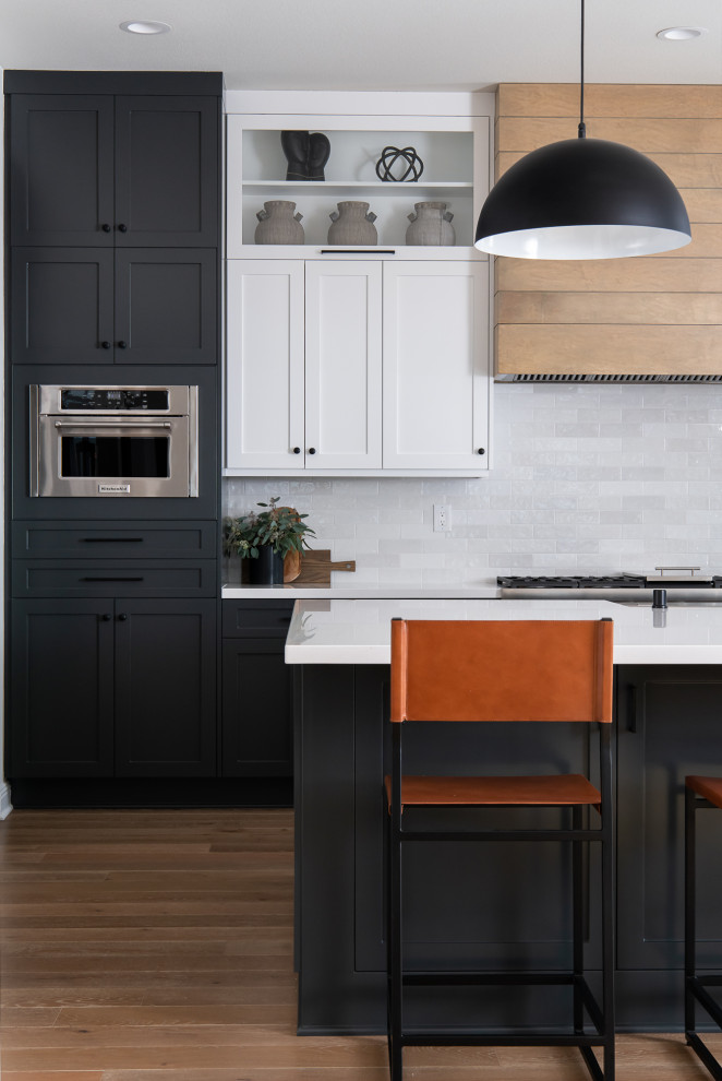 Inspiration for a transitional porcelain tile and gray floor kitchen remodel in Orange County with a farmhouse sink, shaker cabinets, white cabinets, quartzite countertops, white backsplash, subway tile backsplash, stainless steel appliances, an island and white countertops