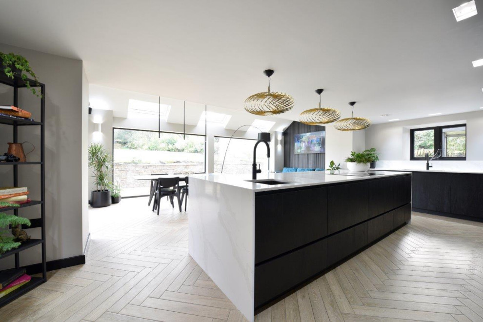 Foto di una grande cucina design con lavello sottopiano, ante lisce, ante nere, top in quarzite, paraspruzzi nero, paraspruzzi in legno, elettrodomestici neri, pavimento in gres porcellanato e top bianco