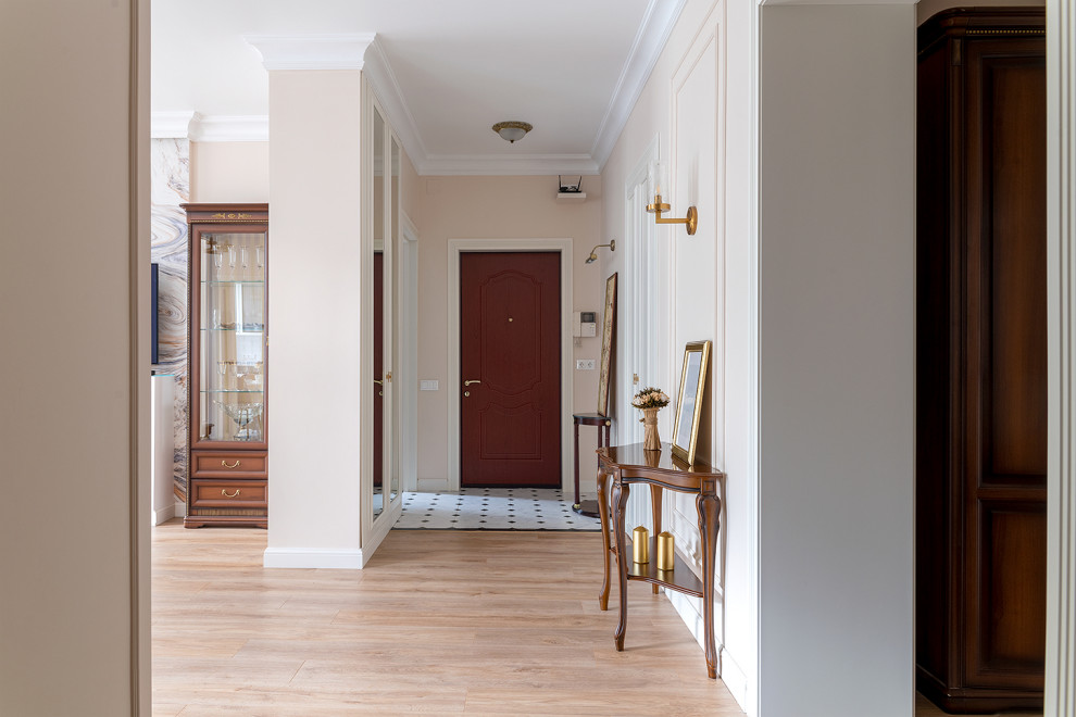 На фото: входная дверь среднего размера в стиле неоклассика (современная классика) с бежевыми стенами, полом из керамогранита, одностворчатой входной дверью, коричневой входной дверью и бежевым полом с