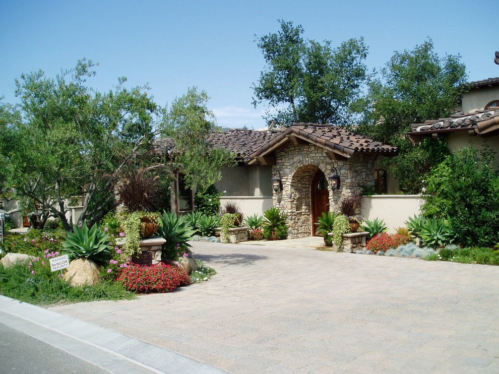 This is an example of a mediterranean two-storey stucco house exterior in San Diego with a shingle roof.