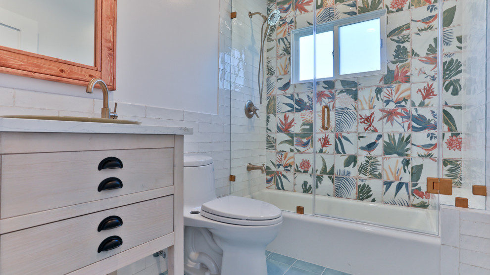 Пример оригинального дизайна: маленькая ванная комната в стиле неоклассика (современная классика) с угловой ванной, душем над ванной, разноцветной плиткой, керамической плиткой, белыми стенами, полом из керамической плитки, мраморной столешницей, синим полом, душем с раздвижными дверями, белой столешницей и тумбой под одну раковину для на участке и в саду