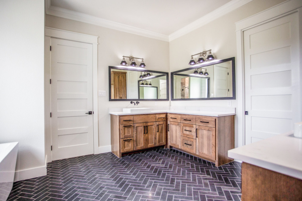 Inspiration for a large country master bathroom in Dallas with shaker cabinets, medium wood cabinets, a freestanding tub, an alcove shower, grey walls, porcelain floors, a vessel sink, quartzite benchtops, black floor, a hinged shower door and white benchtops.