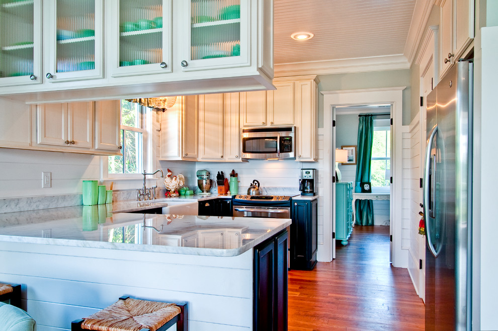 Example of a cottage u-shaped kitchen design in Charleston with a farmhouse sink, recessed-panel cabinets, white cabinets, white backsplash, subway tile backsplash and stainless steel appliances