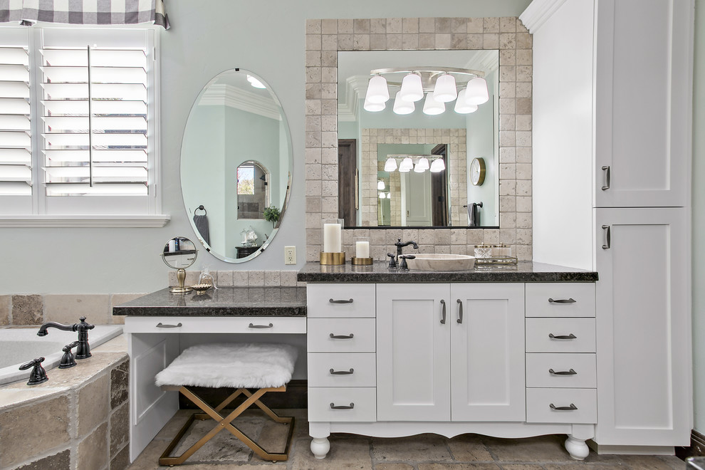 Inspiration for a traditional master bathroom in Salt Lake City with white cabinets, a drop-in tub, beige tile, grey walls, a vessel sink, beige floor, black benchtops and shaker cabinets.