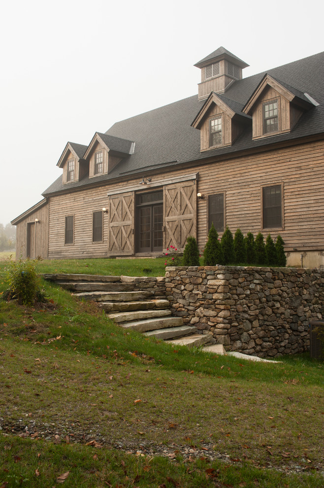 This is an example of a country two-storey exterior in Boston with wood siding and a gable roof.