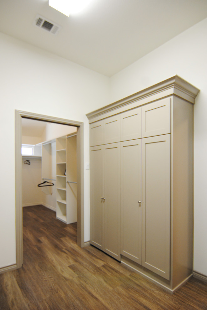 This is an example of a large contemporary galley dedicated laundry room in Austin with recessed-panel cabinets, laminate benchtops, white walls, vinyl floors, a side-by-side washer and dryer and beige cabinets.