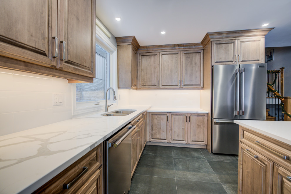 Inspiration for a mid-sized transitional l-shaped eat-in kitchen remodel in Toronto with an undermount sink, raised-panel cabinets, medium tone wood cabinets, quartz countertops, white backsplash, ceramic backsplash, stainless steel appliances, an island and white countertops