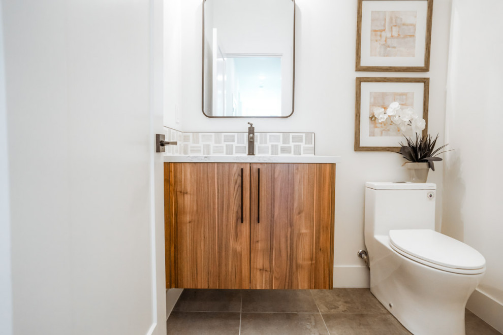 This is an example of a small contemporary 3/4 bathroom in Seattle with flat-panel cabinets, medium wood cabinets, a one-piece toilet, white tile, white walls, ceramic floors, marble benchtops, brown floor, white benchtops, an enclosed toilet, a single vanity, a floating vanity, coffered and an undermount sink.