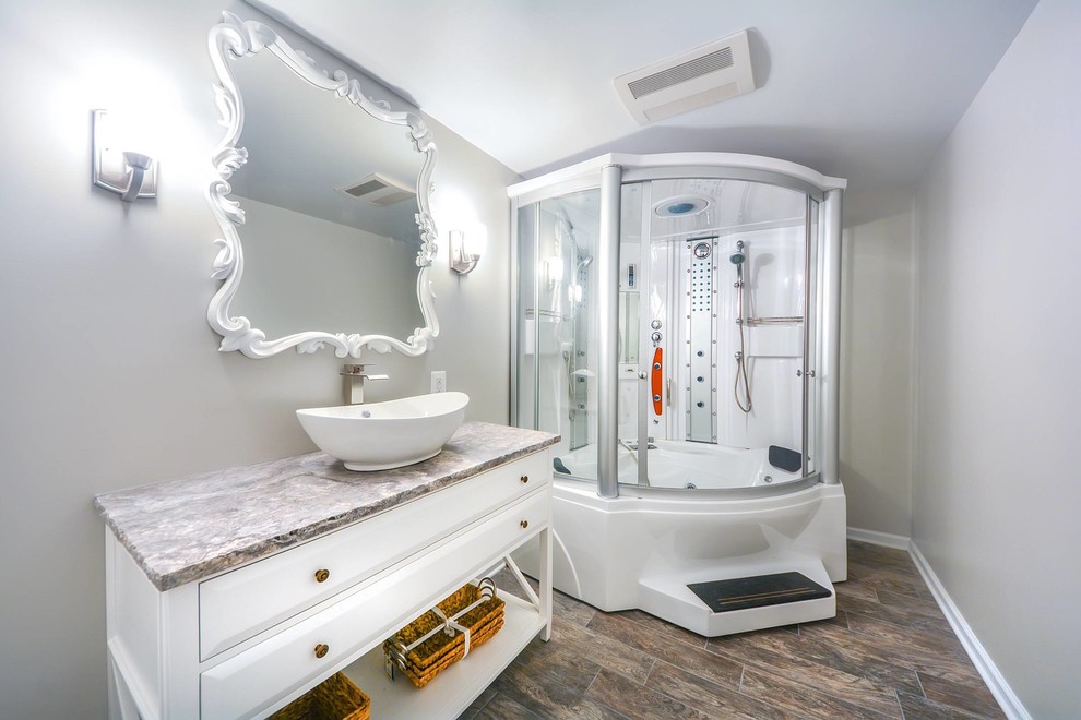 Inspiration for a mid-sized transitional walk-out and master gray tile porcelain tile, brown floor and single-sink tub/shower combo remodel in DC Metro with gray walls, white cabinets, a vessel sink, a one-piece toilet, granite countertops, brown countertops, a freestanding vanity and raised-panel cabinets