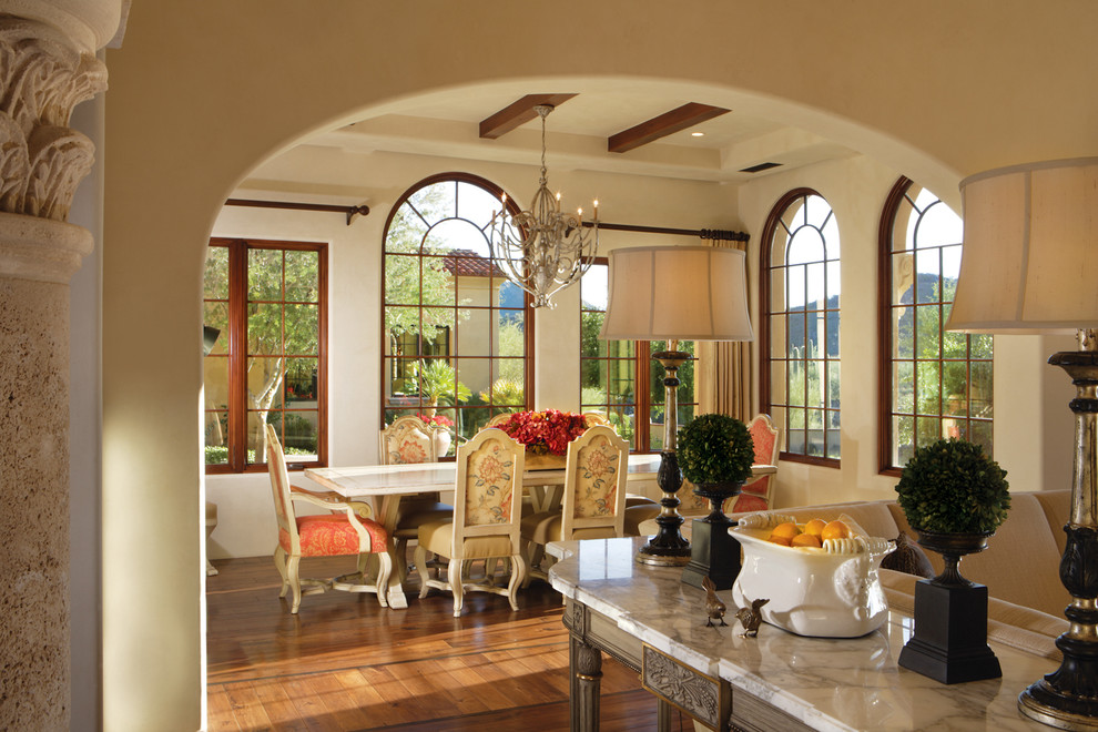 Design ideas for a large mediterranean open plan dining in Phoenix with beige walls, dark hardwood floors, a standard fireplace and a stone fireplace surround.