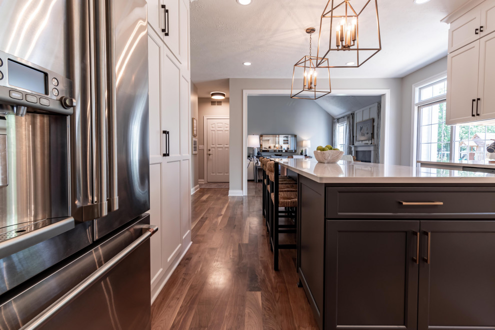 Inspiration for a large transitional u-shaped light wood floor and beige floor kitchen pantry remodel in Cleveland with an undermount sink, shaker cabinets, gray cabinets, quartzite countertops, white backsplash, ceramic backsplash, stainless steel appliances, an island and white countertops