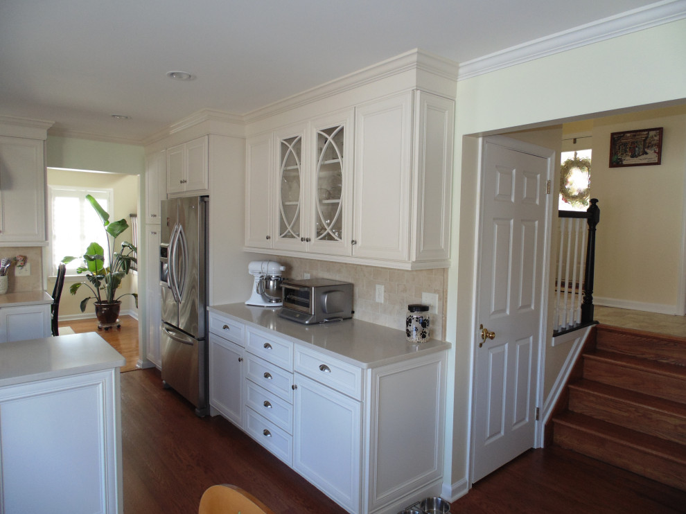 Eat-in kitchen - large transitional u-shaped medium tone wood floor and brown floor eat-in kitchen idea with a farmhouse sink, flat-panel cabinets, white cabinets, quartz countertops, beige backsplash, travertine backsplash, stainless steel appliances and beige countertops