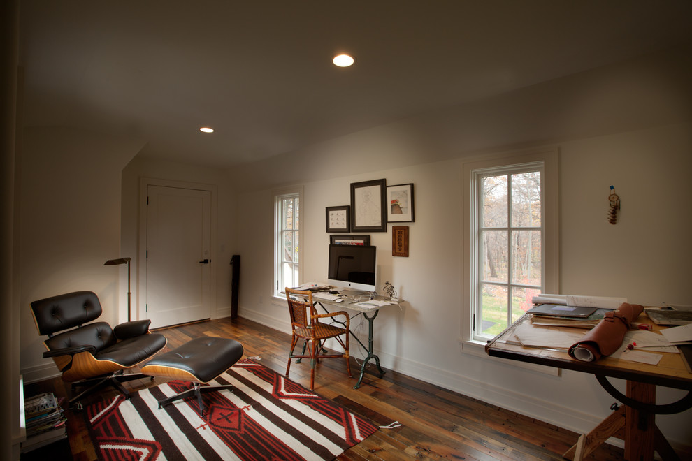 This is an example of a traditional home studio in Minneapolis with white walls, dark hardwood floors and a freestanding desk.