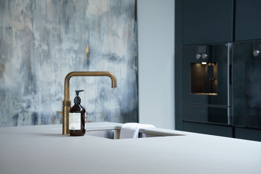 Esempio di una cucina minimalista di medie dimensioni con lavello integrato, ante lisce, top in granito, paraspruzzi in granito e elettrodomestici neri