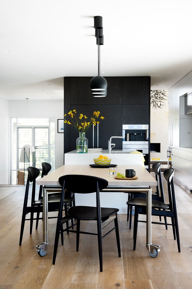 Inspiration for a large contemporary kitchen/dining combo in Sydney with white walls, medium hardwood floors and no fireplace.