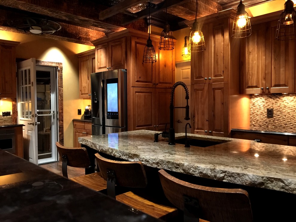 This is an example of a mid-sized country u-shaped eat-in kitchen in New York with an undermount sink, raised-panel cabinets, medium wood cabinets, granite benchtops, brown splashback, stone tile splashback, stainless steel appliances, ceramic floors and with island.