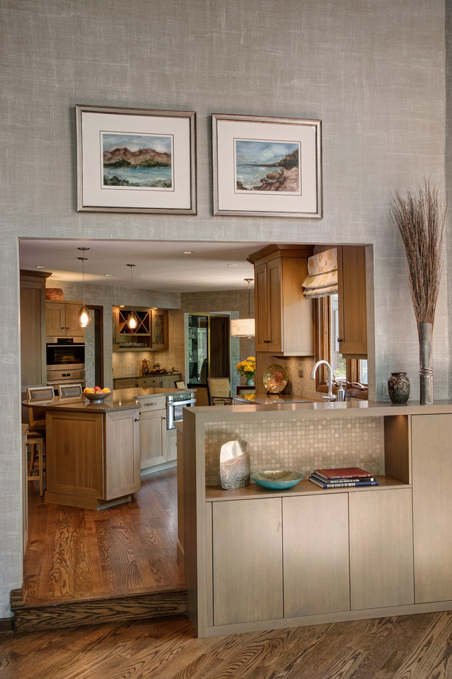 Inspiration for a transitional medium tone wood floor eat-in kitchen remodel in Chicago with a double-bowl sink, shaker cabinets, medium tone wood cabinets, quartz countertops, gray backsplash, stone tile backsplash, stainless steel appliances and an island