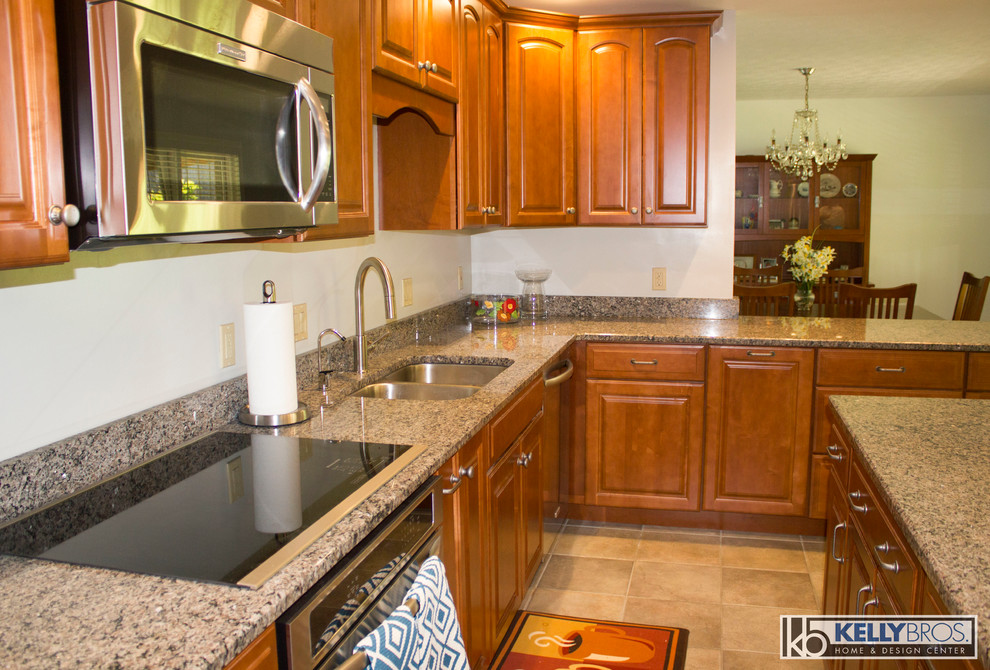 Large transitional u-shaped ceramic tile home design photo in Cincinnati with a double-bowl sink, raised-panel cabinets, medium tone wood cabinets, granite countertops, stainless steel appliances and an island