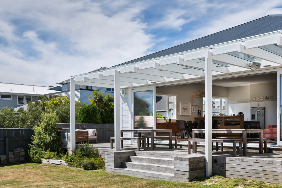 Contemporary backyard patio in Wellington with an outdoor kitchen, decking and a pergola.