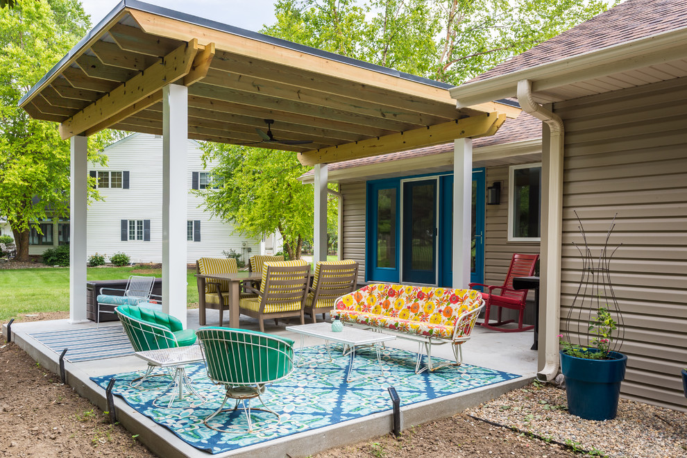 Mid-sized midcentury backyard patio in Omaha with a container garden, concrete slab and a pergola.